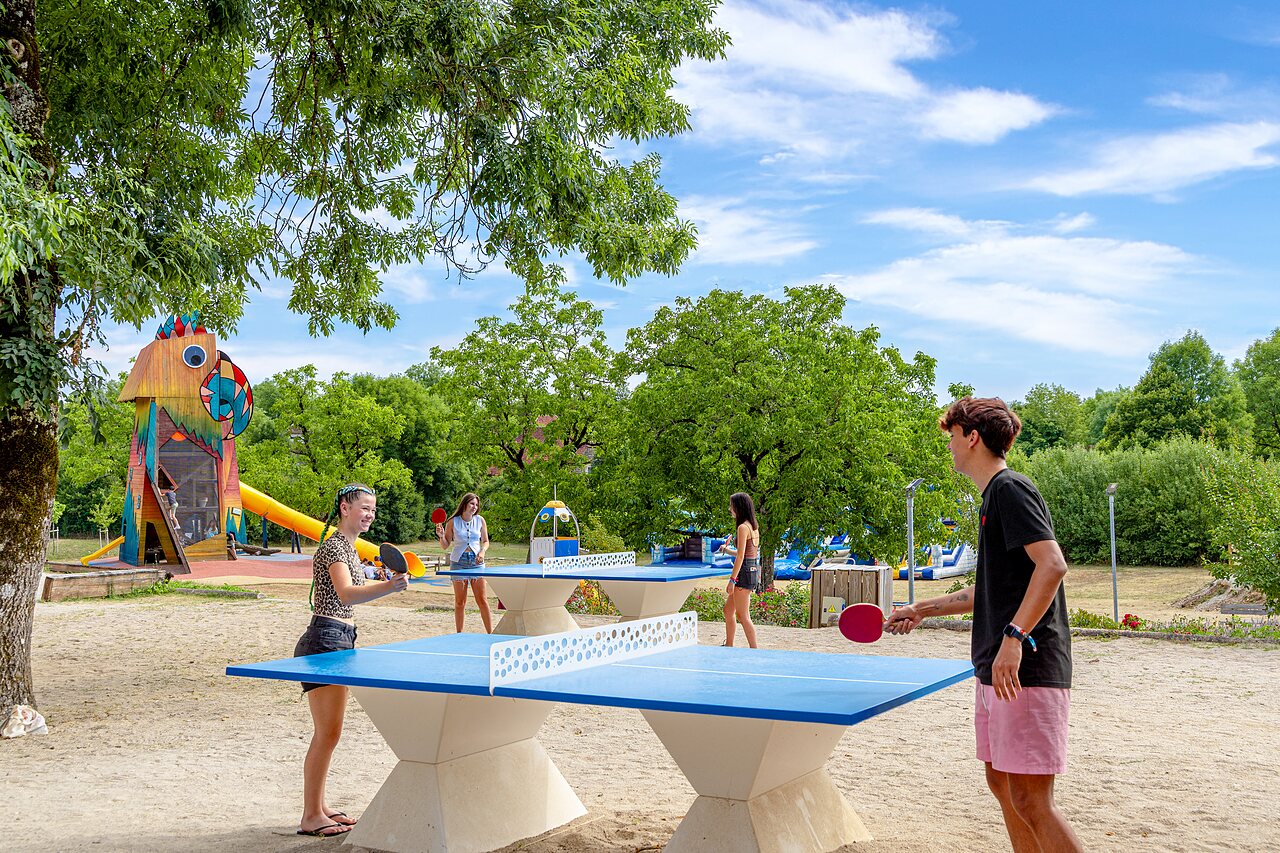 Mesas de ping-pong y parque infantil colorido en el camping CAPFUN Roca d'Amour en PADIRAC (46).