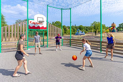 Basketballplatz mit spielenden Kindern auf Campingplatz CAPFUN Roca d'Amour in PADIRAC (46).