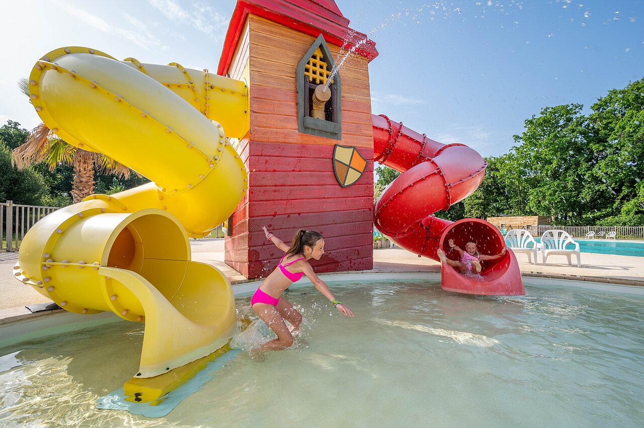 Water slides and children playing in the pool at CAPFUN Roumingue campsite in LANTON (33).
