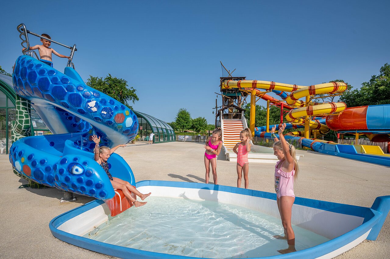 Blue water slide, children having fun at CAPFUN Roumingue campsite in LANTON (33).