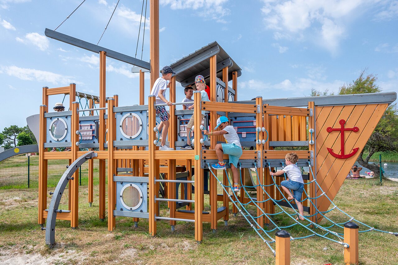 Ship-shaped playground, children climbing, at CAPFUN Roumingue campsite in LANTON (33).