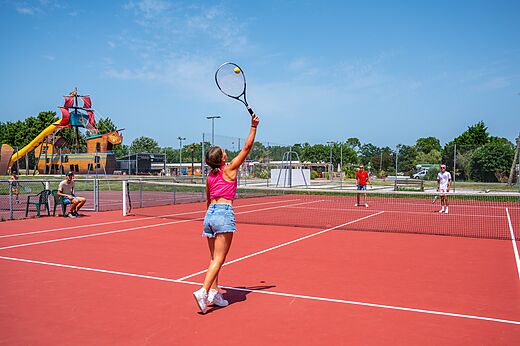 Roter Tennisplatz mit Spielern auf Campingplatz CAPFUN Roumingue, LANTON (33).