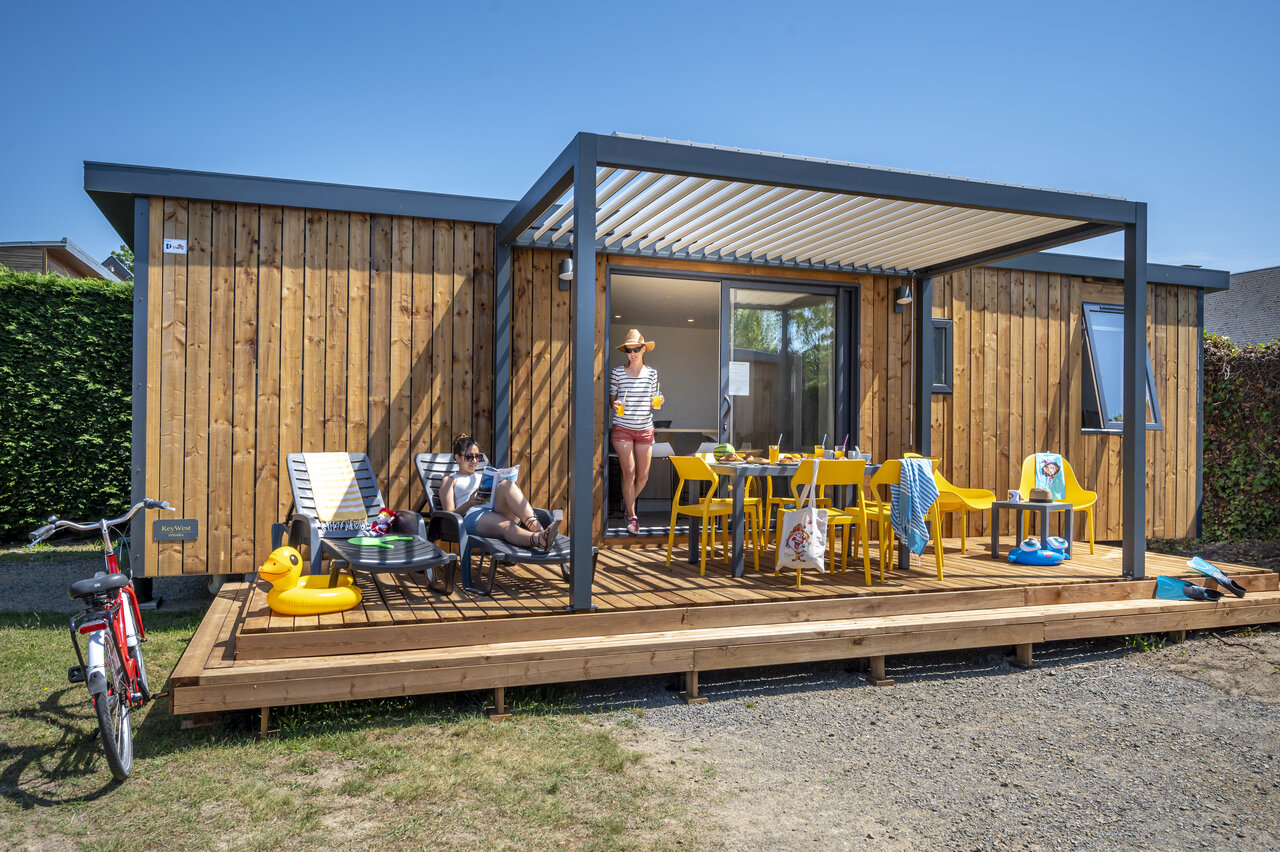 Modernes Mobil-home, Holzterrasse, Familie auf dem Campingplatz CAPFUN La Route Blanche in Breville sur Mer (50).
