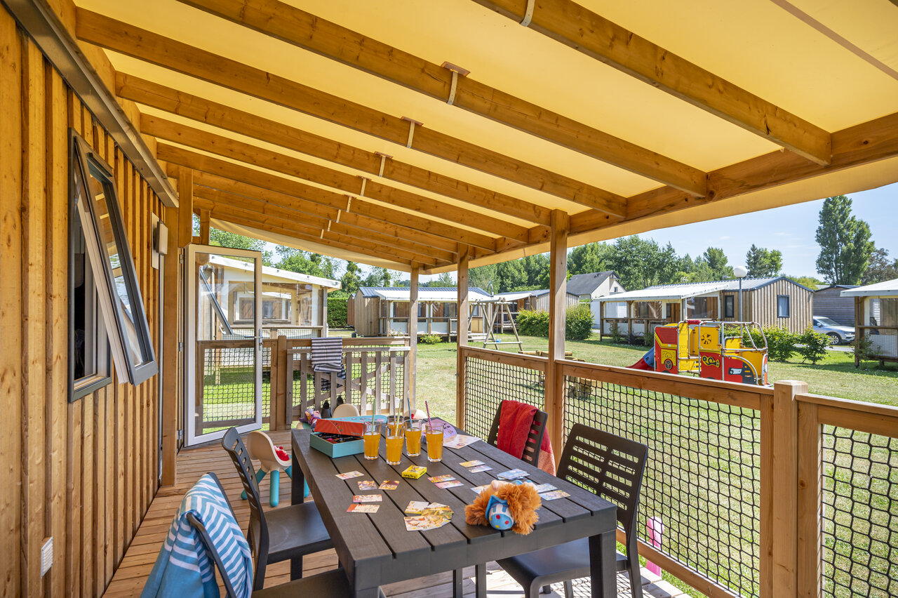 Terrasse eines Mobilheims, Tisch und Kinderspiele auf dem Campingplatz CAPFUN La Route Blanche in Breville sur Mer (50).