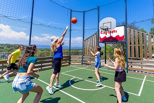 Famille jouant au basketball sur le terrain multisport au camping CAPFUN La Rumba � Fr�jus (83).