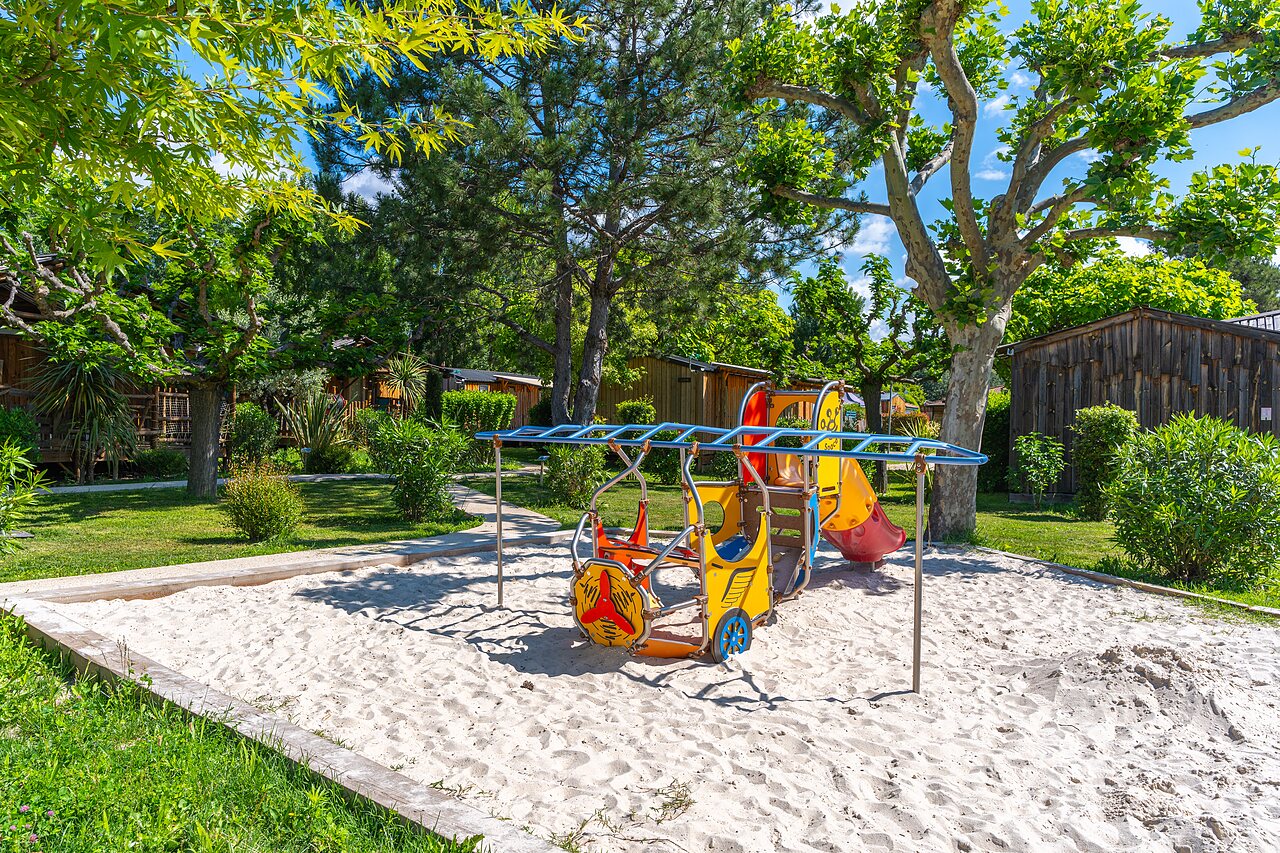 Bunter Spielplatz mit Rutsche und Sand auf dem Campingplatz CAPFUN Sagittaire in VINSOBRES.