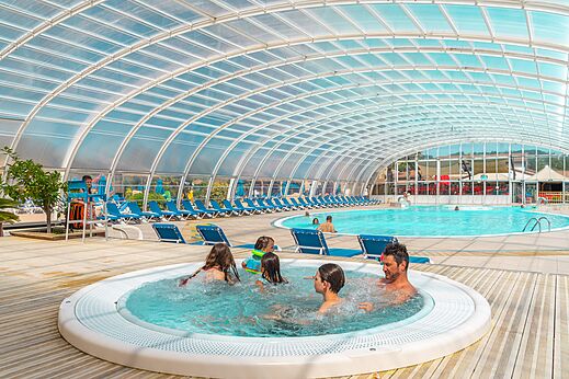 Überdachtes Schwimmbad mit Whirlpool und Familie auf dem Campingplatz CAPFUN Sagittaire in VINSOBRES (26).