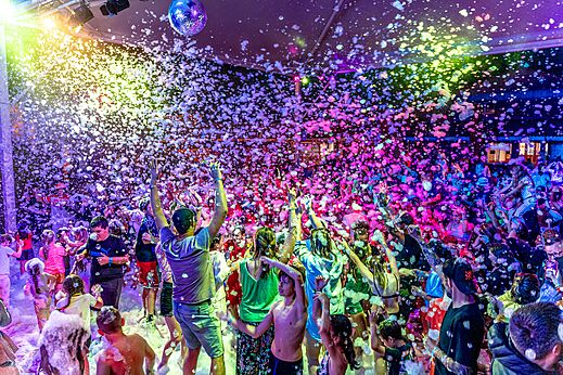 Lebhaftes Schaumparty mit Campern unter bunten Lichtern auf dem Campingplatz CAPFUN Sagittaire in VINSOBRES (26).