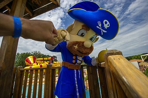 Piratenmaskottchen begr��t ein Kind auf dem Campingplatz CAPFUN Sagittaire in VINSOBRES (26).