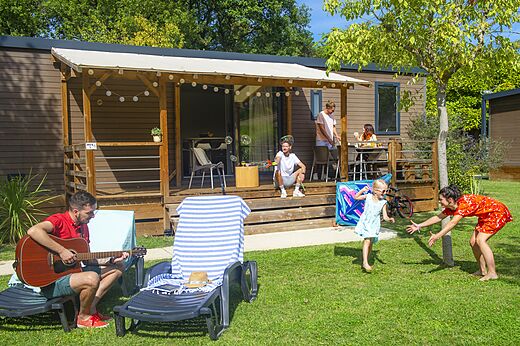 Mobilheim mit überdachter Terrasse und Familie auf dem Campingplatz CAPFUN Sagittaire in VINSOBRES (26).