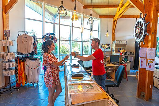 Gast und Mitarbeiter an der Rezeption von Camping CAPFUN Sagittaire in VINSOBRES (26).
