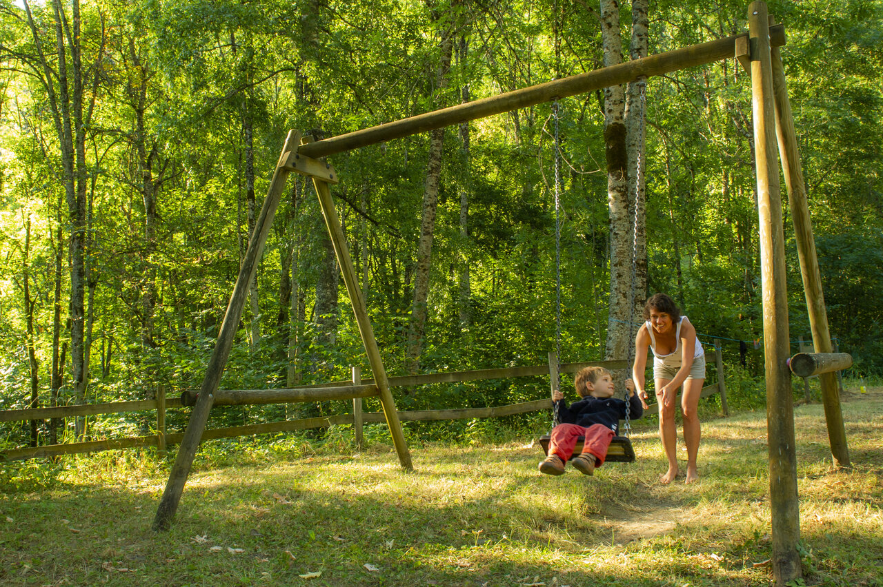 Kind op houten schommel, op camping CAPFUN Saint Colomban in Saint Colomban des Villards (73).