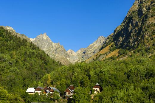 Grüne Berge und traditionelle Häuser im Alpental, Camping CAPFUN Saint Colomban.
