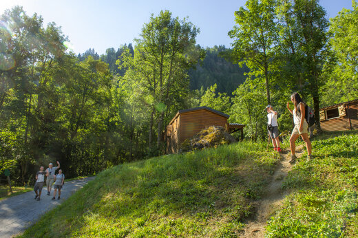 Wanderer auf Waldweg mit Mobilheimen auf Campingplatz CAPFUN Saint Colomban in Saint Colomban des Villards (73).