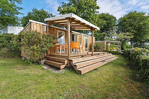 Mobil-home bois, terrasse couverte et chaises au camping CAPFUN Saint Laurent � LA FORET FOUESNANT.