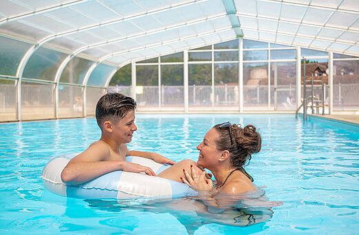 Piscine couverte, mère et enfant souriants au camping CLICOCHIC Les Saules de Cheverny.