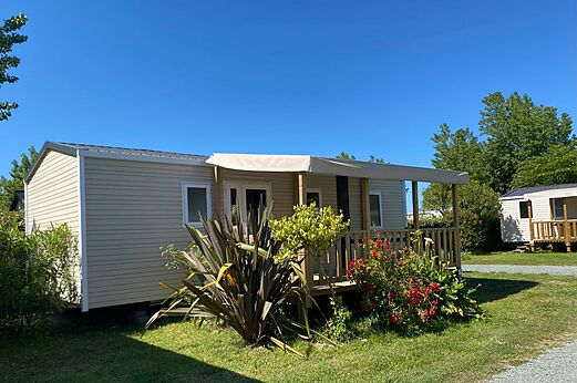 Modernes Mobilheim mit �berdachter Terrasse und Blumengarten auf dem Campingplatz CLICOCHIC Seuli�res in Saint-Denis-d'Ol�ron (17).