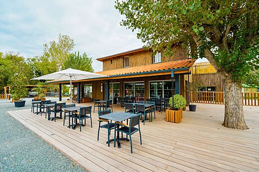 Restaurantterrasse mit Tischen und Sonnenschirm auf CLICOCHIC Seuli�res Saint-Denis-d'Ol�ron.