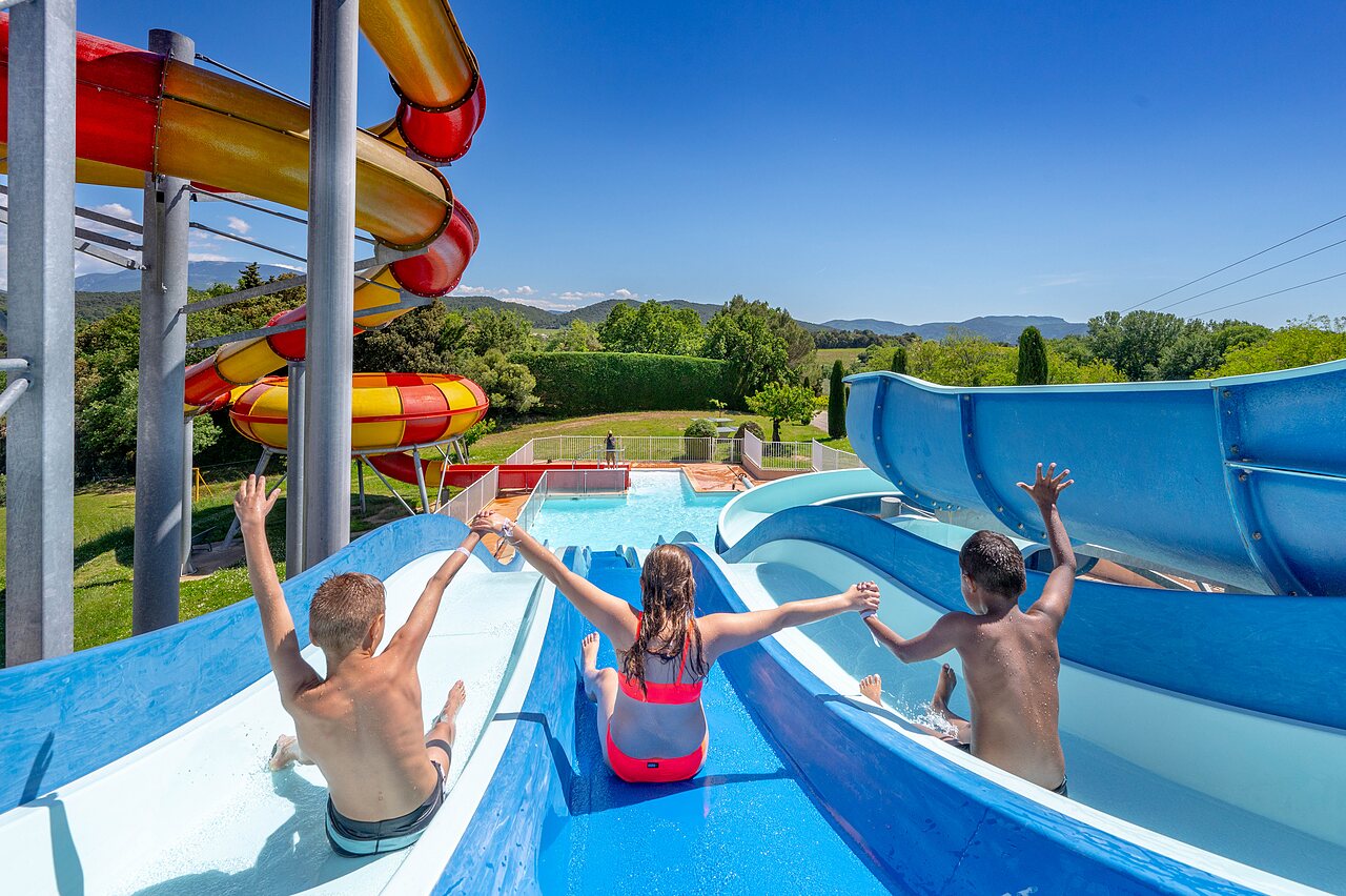 Kinder auf riesigen Wasserrutschen und Pool auf dem Campingplatz VAGUES OCEANES Soleil de Provence in Saint-Romain-en-Viennois (84).