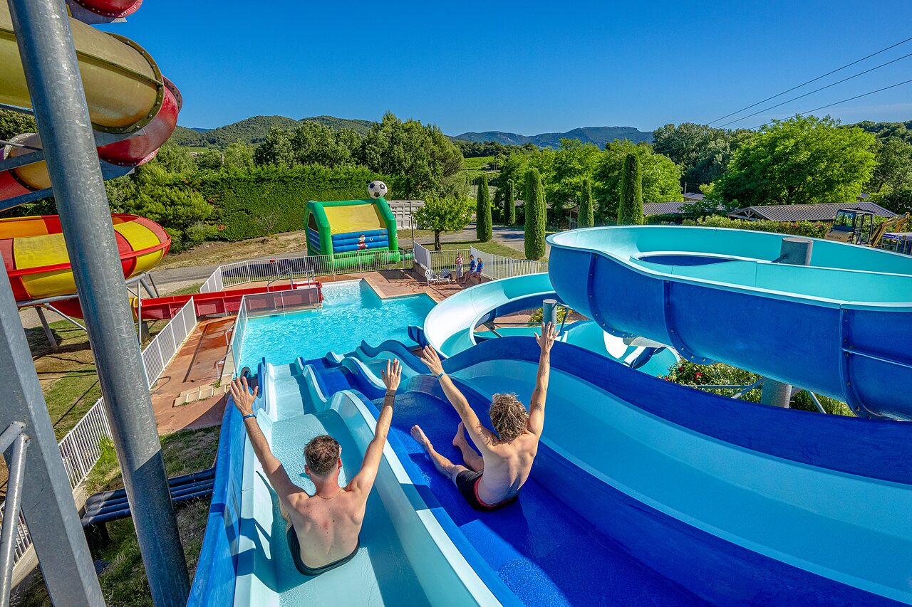 Blauwe waterglijbanen en buitenzwembad op camping VAGUES OCEANES Soleil de Provence (84).