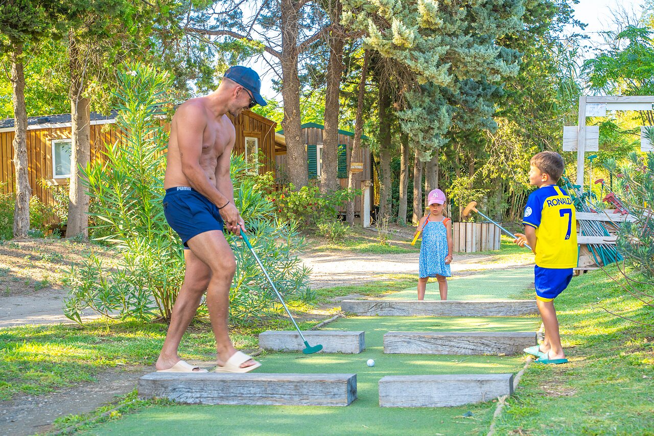 Famille jouant au mini-golf pr�s des Mobil-homes au camping CAPFUN Soubeyranne � REMOULINS (30).