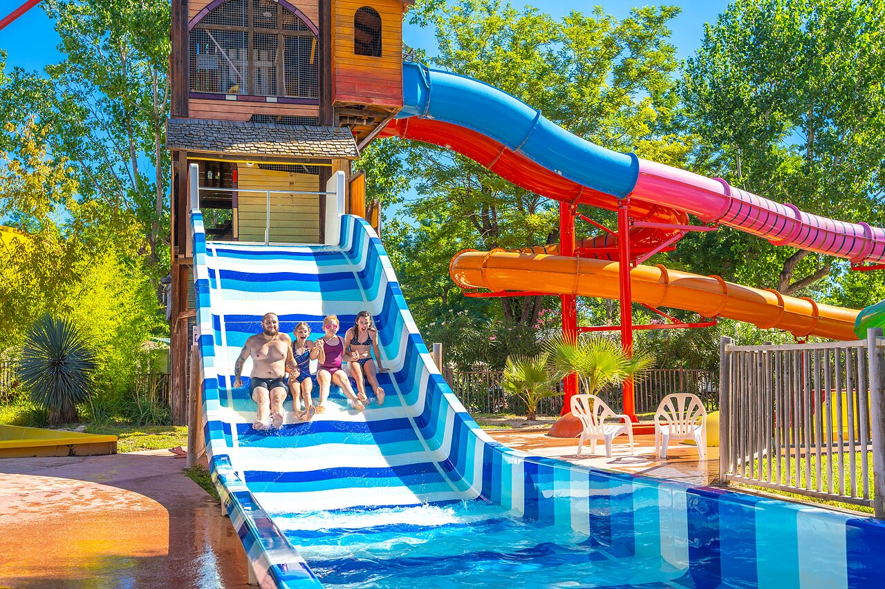 Famille descendant un grand toboggan aquatique ray� au camping CAPFUN Soubeyranne � REMOULINS (30).