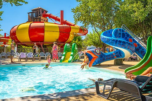 Bunte Wasserrutschen und Pool mit spielenden Kindern auf dem Campingplatz CAPFUN Soubeyranne in REMOULINS (30).