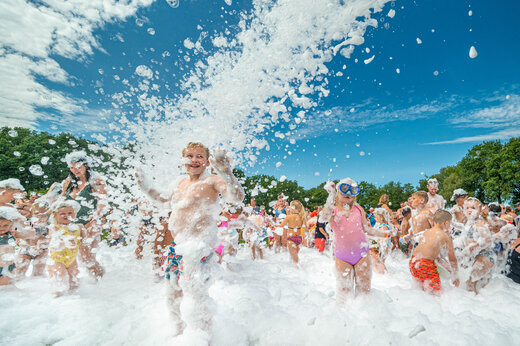 Kinder und Erwachsene genießen ein Schaumfest auf dem Campingplatz CAPFUN De Sprookjescamping in Rheeze.