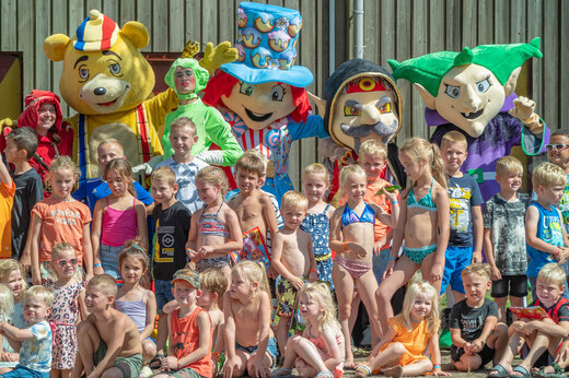 Kinder posieren mit Animationsmaskottchen auf dem Campingplatz CAPFUN De Sprookjescamping in Rheeze.
