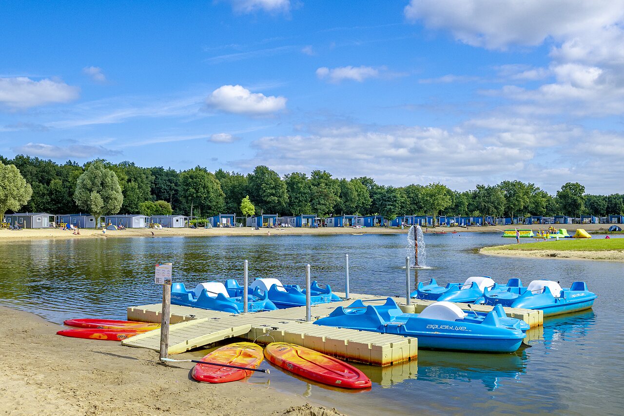Tretboote, Kajaks und Sandstrand am See auf dem Campingplatz CAPFUN het Stoetenslagh in Rheezerveen.