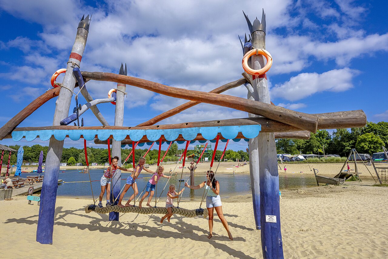 H�lzernes Spielger�t am Sandstrand mit Kindern auf dem Campingplatz CAPFUN Vakantiepark Capfun het Stoetenslagh in Rheezerveen.