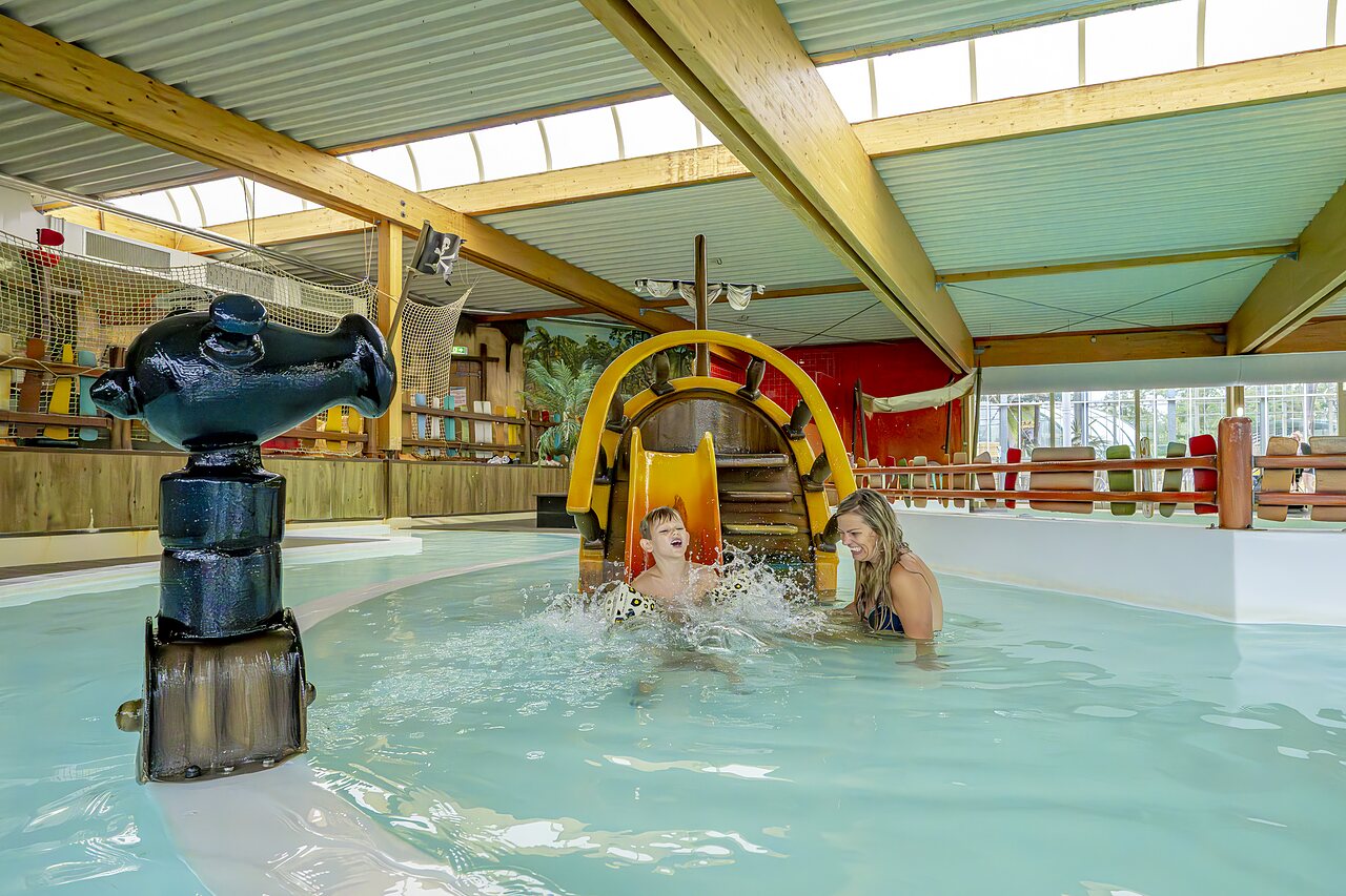 Kind und Frau lachend auf Piraten-Wasserrutsche im Hallenbad auf Camping CAPFUN Vakantiepark Capfun het Stoetenslagh in Rheezerveen.