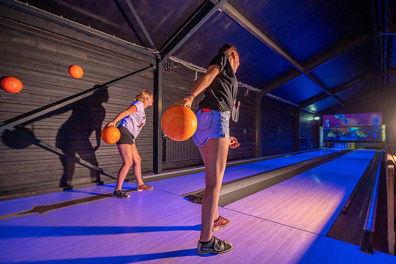 Jugendliche spielen Bowling auf beleuchteten Bahnen auf dem Campingplatz CAPFUN Vakantiepark het Stoetenslagh in Rheezerveen.