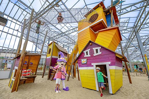 Indoor-Spielplatz mit Netzen, bunten Häusern und Sand auf dem Campingplatz CAPFUN Vakantiepark Capfun het Stoetenslagh in Rheezerveen.