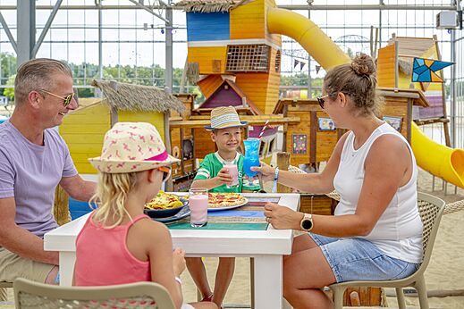 Familie isst im Restaurant des Campingplatzes CAPFUN Vakantiepark Capfun het Stoetenslagh.