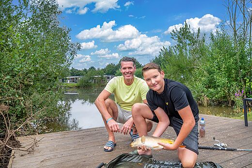 Vater und Sohn angeln Karpfen auf dem Campingplatz CAPFUN Vakantiepark Capfun het Stoetenslagh in Rheezerveen.