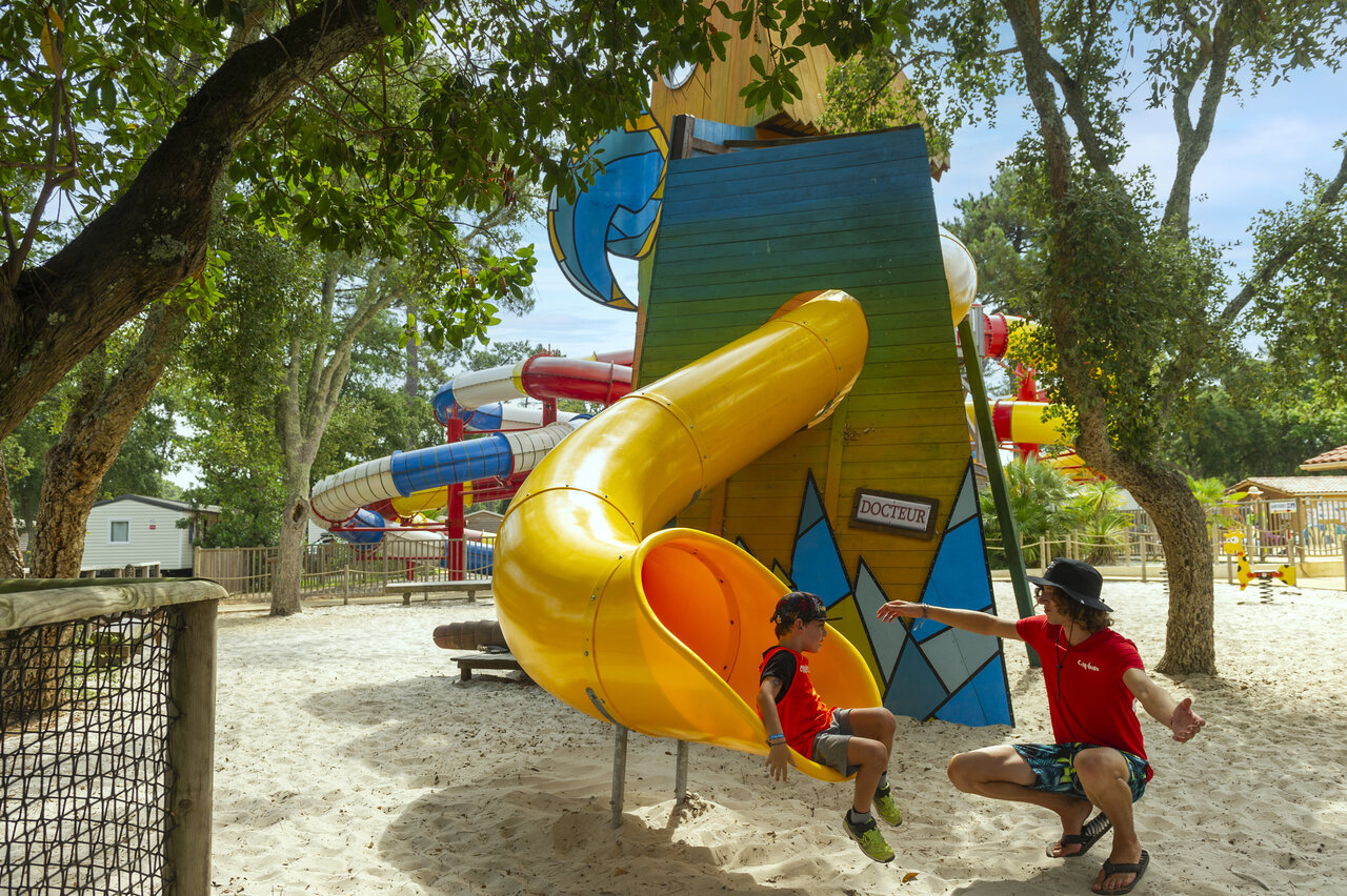 Yellow slide, child with animator at CAPFUN Sud Land campsite in Labenne-Ocean.