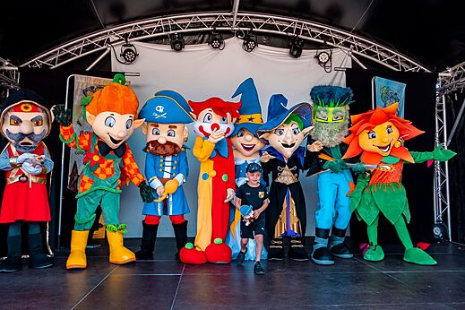 Maskottchen und Kind auf Animationsbühne auf dem Campingplatz CAPFUN Sud Land in Labenne-Ocean.