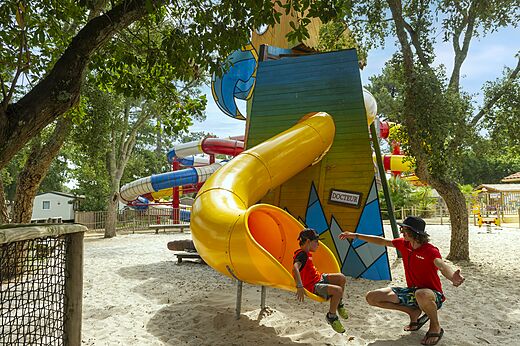 Kind auf gelber Rutsche Sandspielplatz auf dem Campingplatz CAPFUN Sud Land in Labenne-Ocean (40).