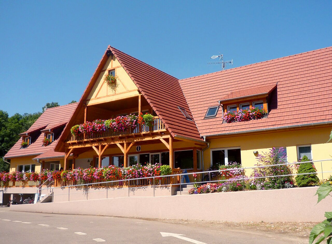 Blumengeschm�ckte Hauptrezeption mit Balkon auf Camping CAPFUN Suzel in Sainte-Croix-en-Plaine (68).