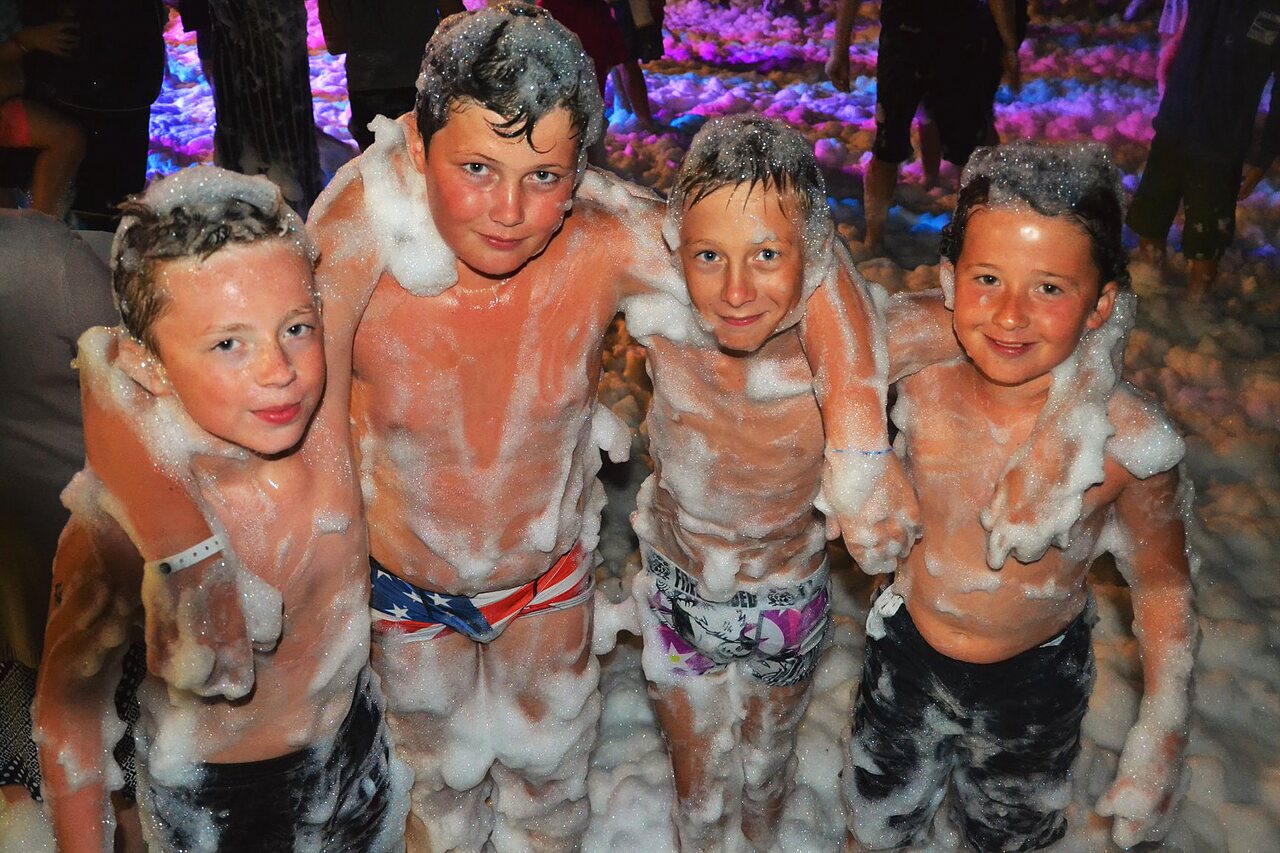Smiling children enjoying a lively foam party at CAPFUN Talaris Vacances campsite in Lacanau (33).