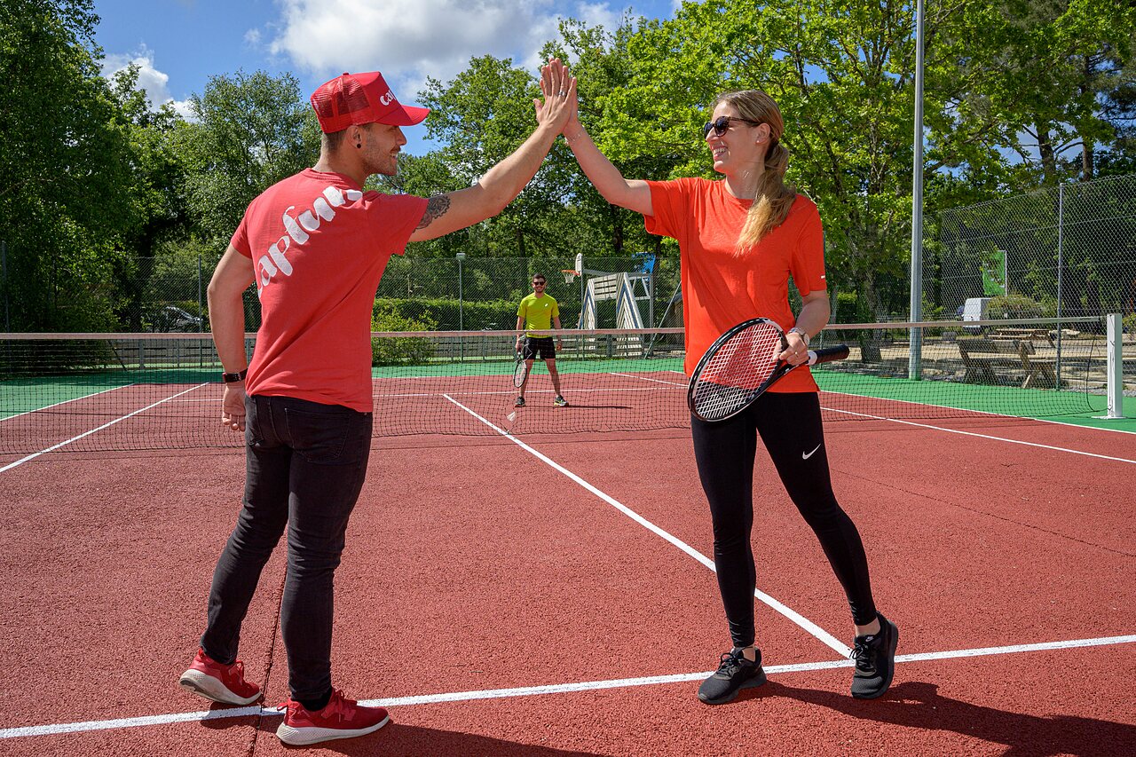 Tennis players high-fiving on the multi-sport court at CAPFUN Talaris Vacances campsite in Lacanau (33).