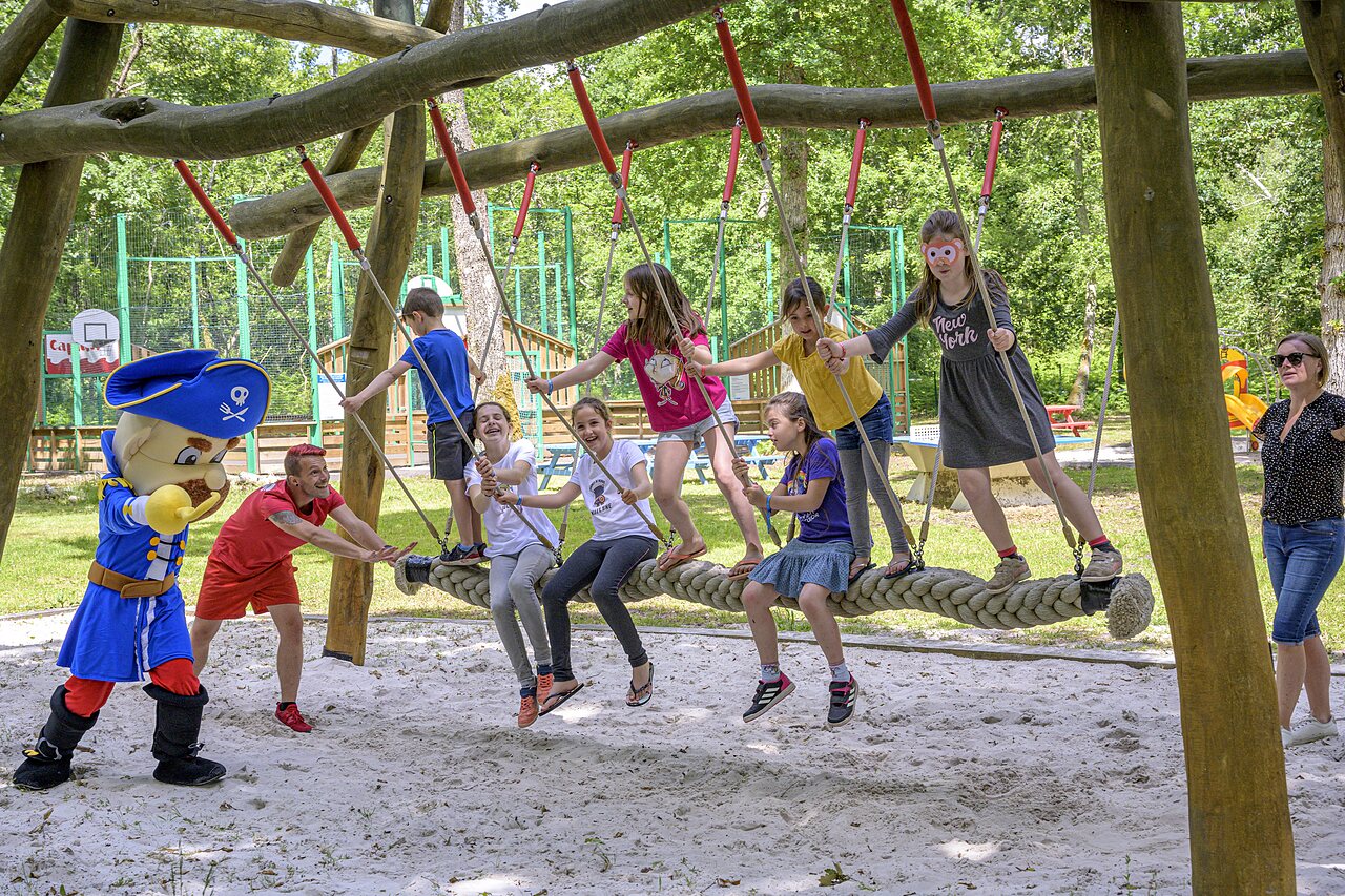 Mascot, children on giant swing at CAPFUN Talaris Vacances campsite in Lacanau.