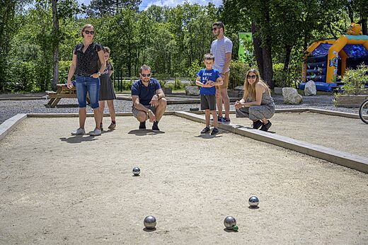 Famille jouant à la pétanque sur le terrain au camping CAPFUN Talaris Vacances.