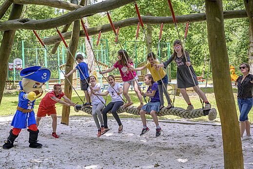 Enfants s'amusant sur balançoire géante au camping CAPFUN Talaris Vacances Lacanau (33).