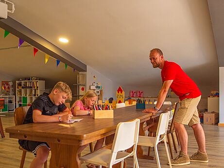 Kinder malen am Tisch mit Animateur auf dem Campingplatz CAPFUN Tecklenburg in Tecklenburg-Leeden (49).