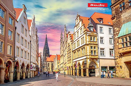 Rue historique avec bâtiments traditionnels et cathédrale à Münster, Allemagne.