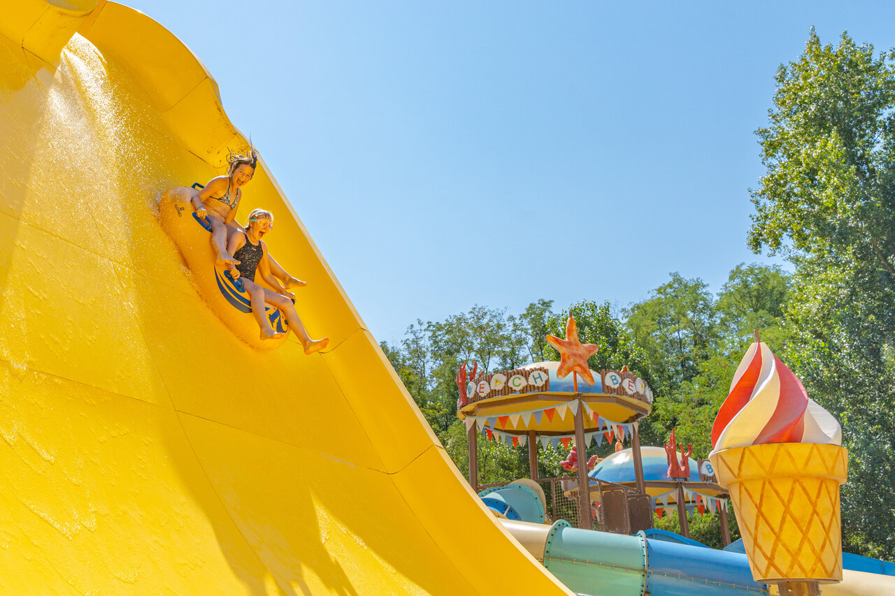 Kinder rutschen eine gro�e gelbe Wasserrutsche hinunter auf Camping CAPFUN Temps Libre in BOUGE CHAMBALUD (38).