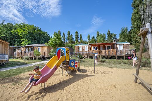 Spielplatz mit Rutsche und Mobilheime auf Camping CAPFUN Temps Libre in BOUGE CHAMBALUD.
