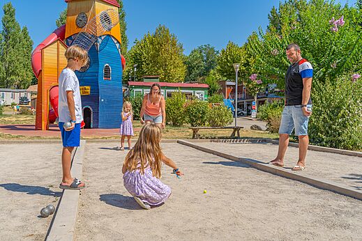 Familie spielt Boule auf dem Platz, mit Spielplatz auf dem Campingplatz CAPFUN Temps Libre in BOUGE CHAMBALUD (38).
